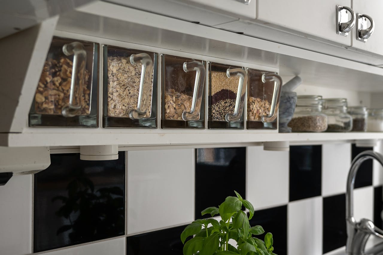 Glass containers with grains on a kitchen shelf, perfect for storage inspiration.