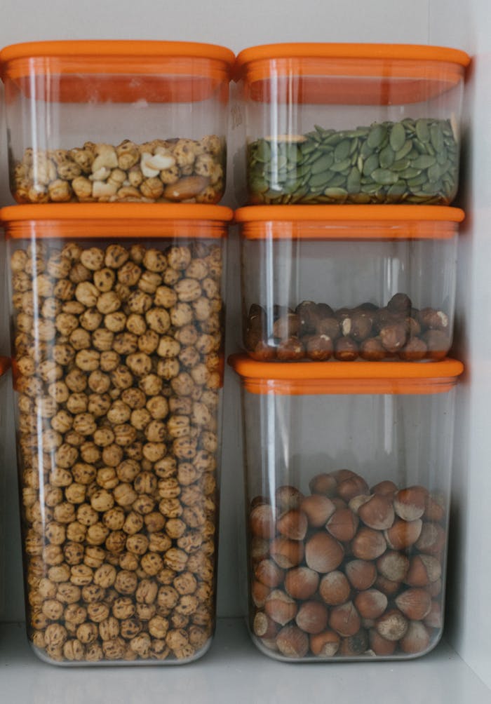 Neatly organized plastic containers filled with various nuts and seeds.